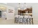 Well-lit kitchen with a white countertop island, bar seating, and stainless steel appliances, seamlessly connected to the dining area at 1324 Arklow Cir, Ormond Beach, FL 32174