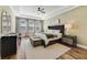 Bright main bedroom featuring hardwood floors, decorative wallpaper, tray ceiling, and serene decor at 1324 Arklow Cir, Ormond Beach, FL 32174