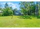 Expansive backyard view featuring lush lawn and mature trees at 13344 S Lake Mary Jane Rd, Orlando, FL 32832