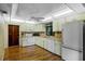 Well-lit kitchen featuring ample cabinet space, appliances, and wood flooring at 13344 S Lake Mary Jane Rd, Orlando, FL 32832