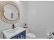 Chic half-bathroom with modern fixtures, a round gold mirror, and a blue vanity at 1465 Osprey Ridge Dr, Eustis, FL 32736