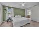 Bright bedroom featuring a unique green accent wall, neutral carpet, and natural light from the window at 1465 Osprey Ridge Dr, Eustis, FL 32736