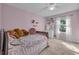 Pink bedroom featuring a patterned bedspread, natural light, and comfortable carpet at 1465 Osprey Ridge Dr, Eustis, FL 32736