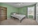 Neutral bedroom with black metal bed frame, light carpet, and natural light at 1465 Osprey Ridge Dr, Eustis, FL 32736