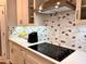 Close-up of a modern kitchen with stainless steel hood and range top, mosaic backsplash, and ample storage at 15209 Lake Lamonia St, Winter Garden, FL 34787