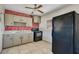 Kitchen featuring painted brick accent wall, neutral cabinets and black appliances at 1523 Silver Star Rd, Orlando, FL 32804