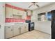 Kitchen featuring painted brick accent wall, neutral cabinets and black appliances at 1523 Silver Star Rd, Orlando, FL 32804