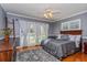 Well-lit bedroom with hardwood floors, a ceiling fan, and large windows dressed with curtains and shutters at 1591 Chippewa Trl, Maitland, FL 32751