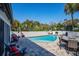 Beautiful backyard featuring a pool, lounge chairs, a dining table, and lush landscaping, perfect for relaxation at 1591 Chippewa Trl, Maitland, FL 32751