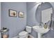 Stylish powder room features a pedestal sink, round mirror, and a water closet at 1725 Prospect Ave, Orlando, FL 32814