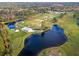 Aerial view of golf course, clubhouse, and picturesque lake with surrounding greenery at 1921 Redwood Grove, Lake Mary, FL 32746