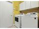 Well-lit laundry room with appliances, cabinet storage, and tiled floors, blending practicality with ample space at 1921 Redwood Grove, Lake Mary, FL 32746