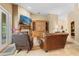 Inviting living room with fireplace, TV, wooden built-ins, and comfortable leather chairs at 1921 Redwood Grove, Lake Mary, FL 32746