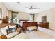 Spacious main bedroom with neutral carpet, ceiling fan, seating area and warm wood furniture at 1921 Redwood Grove, Lake Mary, FL 32746