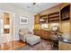 Charming home office featuring custom built-ins, chair, ottoman, hardwood floors, and an elegant area rug at 1921 Redwood Grove, Lake Mary, FL 32746