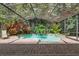 Beautiful pool with a screened enclosure and paver decking, surrounded by vibrant tropical plants and lush landscaping at 1921 Redwood Grove, Lake Mary, FL 32746