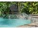 Beautiful pool with rock waterfall feature surrounded by lush tropical landscaping at 1921 Redwood Grove, Lake Mary, FL 32746