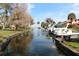 Waterfront view on a canal with boats docked along the shore, showcasing waterfront property at 201 Clusterwood Dr, Yalaha, FL 34797