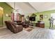 Bright living room showcasing the vaulted ceilings, wood-look tile floor, and comfortable brown leather sofa at 2405 Abalone Blvd, Orlando, FL 32833