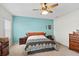 Comfortable bedroom with a ceiling fan and a striking turquoise accent wall at 2537 Rock Pl, Poinciana, FL 34759