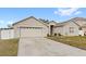 Exterior shot of single-story home with a driveway leading to the attached garage at 2537 Rock Pl, Poinciana, FL 34759