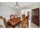 Elegant dining room featuring a large wooden table, ornate chairs, and a decorative chandelier with adjacent living room views at 259 Westchester Dr, Deland, FL 32724