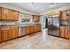 Well-lit kitchen featuring stainless steel appliances, wood cabinets, tile flooring, and an exterior door at 259 Westchester Dr, Deland, FL 32724