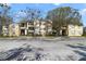 Exterior of a light yellow two-story apartment building complex on a sunny day with reserved parking spaces at 2624 Robert Trent Jones Dr # 634, Orlando, FL 32835