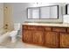 Bathroom vanity featuring wood cabinets and a white sink with a granite countertop and a tile shower and bath at 2624 Robert Trent Jones Dr # 634, Orlando, FL 32835