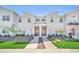 Modern townhome featuring clean lines, red doors, xeriscaping, and a well manicured lawn at 3007 Penelope Loop, Kissimmee, FL 34746