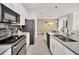 Bright kitchen featuring stainless steel appliances, tile backsplash, and open layout to the dining area at 3007 Penelope Loop, Kissimmee, FL 34746