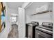 Bright laundry room with modern washer and dryer, complemented by a view into the bedroom at 3007 Penelope Loop, Kissimmee, FL 34746