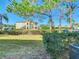 Exterior view of the home with mature landscaping, green grass, a blue sky and off street parking at 3206 Sabal Palms Ct # A, Kissimmee, FL 34747