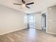 Bright main bedroom featuring wood-look floors, a ceiling fan, and sliding door access to the yard at 3206 Sabal Palms Ct # A, Kissimmee, FL 34747