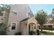 Front exterior view of a well-kept townhome featuring a quaint porch and tidy landscaping at 3364 Westchester Square Blvd # 104, Orlando, FL 32835