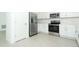 Modern kitchen with stainless steel appliances, white cabinetry and light gray tile flooring at 338 Wayland Dr, Haines City, FL 33844