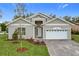 Charming home with a white garage door, gray siding, and a well manicured yard at 340 Bahia Cir, Longwood, FL 32750