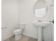 Bathroom featuring a pedestal sink, oval mirror, and tile flooring at 3507 Salvia Ct, Tavares, FL 32778