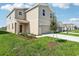 Tan two-story home with a covered porch, a two-car garage, and a green lawn at 3507 Salvia Ct, Tavares, FL 32778