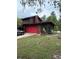 Charming log cabin style home features a red garage door and verdant lawn at 40201 Jericho Trl, Eustis, FL 32736