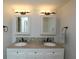 Bathroom featuring dual sinks with granite countertops, modern light fixtures, and tiled backsplash at 4117 Fairview Vista Pt # 105, Orlando, FL 32804