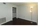 Cozy bedroom with dark wood floors, fresh white paint, and closet featuring wire shelving at 4117 Fairview Vista Pt # 105, Orlando, FL 32804