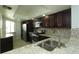 Granite countertops and a stainless steel sink compliment the dark cabinets in this updated kitchen at 4117 Fairview Vista Pt # 105, Orlando, FL 32804