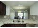 Granite counters and a stainless steel sink offer a view into the dining room in this updated kitchen at 4117 Fairview Vista Pt # 105, Orlando, FL 32804