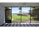 View from the screened porch with tile floors overlooking a landscaped lawn, pool, and lake at 4117 Fairview Vista Pt # 105, Orlando, FL 32804