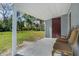 Covered back porch with seating overlooks a spacious, grassy backyard with mature trees at 4228 Lenox Blvd, Orlando, FL 32811