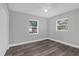 Bedroom with hardwood floors, ceiling fan, and two bright windows at 4228 Lenox Blvd, Orlando, FL 32811