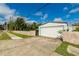 Exterior of a two car garage with long driveway, sidewalk, and a well maintained lawn at 4416 Flagg St, Orlando, FL 32812