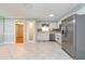 Open kitchen layout featuring stainless appliances, white cabinets, and tile flooring for a seamless design at 4416 Flagg St, Orlando, FL 32812