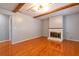 Warm living room with hardwood floors, exposed beams, and a brick fireplace creating a cozy atmosphere at 4416 Flagg St, Orlando, FL 32812